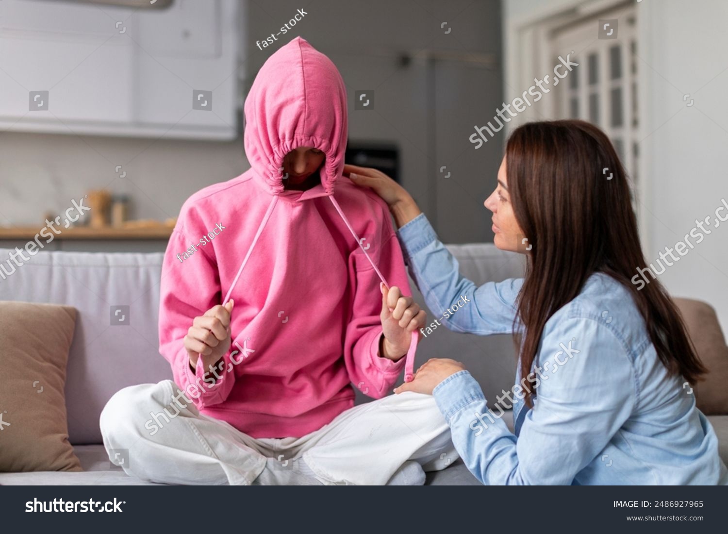 stock-photo-stubborn-upset-teenage-girl-putting-hood-on-head-and-avoiding-her-mom-apology-ignoring-talk-with-2486927965